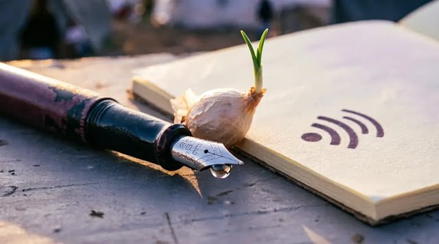 Brushed steel pen with mature ink patina beside blank notebook with sprouting onion seed at twilight. (AI-generated illustration)