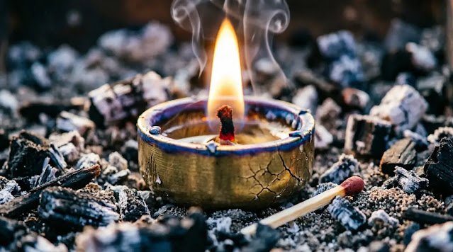 Brass votive with glowing ember wick in dark ash bed, heat distortion reveals flame. (AI-generated illustration)