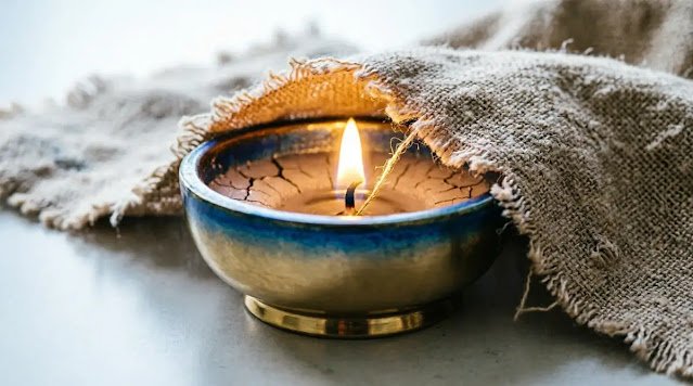 Brass votive with steady flame partially covered by fabric, glow reveals intensity. (AI-generated illustration)